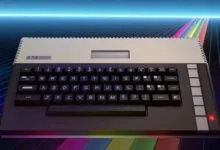 An Atari 800XL computer sits on a reflective surface against a retro futuristic neon grid background.