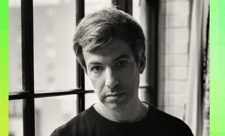 Portrait of comedian and filmmaker Nathan Fielder against a window with bright green side borders