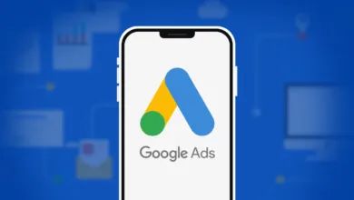 Smartphone displaying the Google Ads logo against a blue background with digital marketing icons.