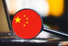 Magnifying glass focused on the Chinese flag resting on a laptop keyboard