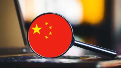 Magnifying glass focused on the Chinese flag resting on a laptop keyboard