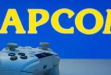 A light blue gaming controller rests in front of a blue background featuring yellow Capcom branding.