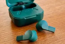 Fairphone Fairbuds wireless earbuds in teal green with their matching charging case