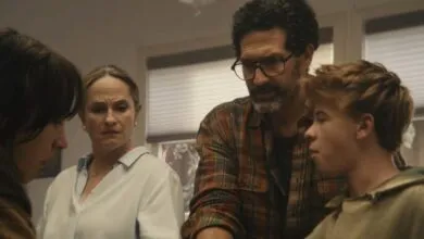 A concerned family gathers indoors, looking tense and focused on a situation.