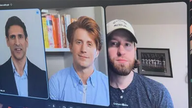 Three men participating in a video conference call on a computer monitor