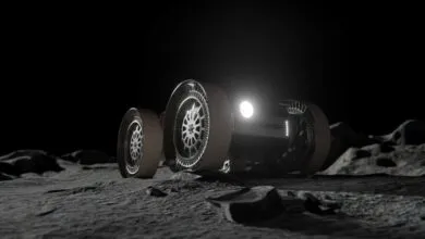 Futuristic lunar rover equipped with advanced transformable wheels traversing a dark, rocky moon surface.