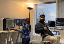 Floqer founders collaborating in a modern office with dual monitors and coding setups.