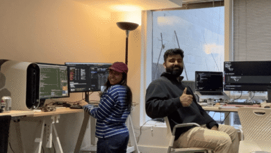 Floqer founders collaborating in a modern office with dual monitors and coding setups.