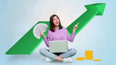 A smiling woman sits with a laptop, holding cash, pointing at a large green upward-trending arrow.