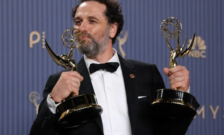 Director and writer Justin Kurzel happily holds two golden Emmy statues.