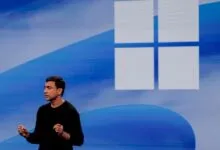 Pavan Davuluri speaks on stage in front of a large blue Microsoft Windows logo.