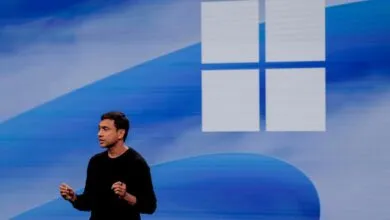 Pavan Davuluri speaks on stage in front of a large blue Microsoft Windows logo.
