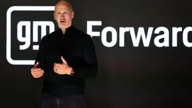 Kurt Kelty speaking on stage in front of a GM Forward backdrop with the General Motors logo.