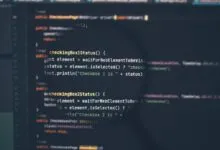 Magnifying glass focused on computer programming code displayed on a dark screen.