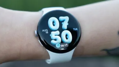 Close-up of a smartwatch with a round screen displaying puffy blue numbers on a person's wrist.