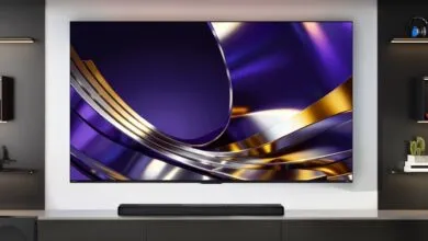 Large wall-mounted flat screen TV displaying a vibrant purple and gold abstract wallpaper in a modern living room