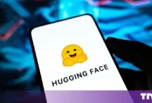 Smartphone displaying the Hugging Face logo against a glowing blue technological background