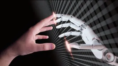 A human hand and a robot hand reach toward each other through a digital grid pattern.