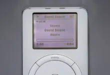 Close-up of a vintage white iPod screen displaying David Bowie playing