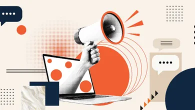 A hand emerges from a laptop screen holding a megaphone surrounded by communication icons.