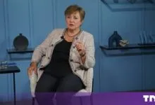 Kristalina Georgieva seated on a blue set, speaking and gesturing during an interview.