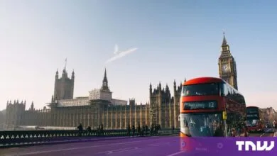A red double-decker bus crossing Westminster Bridge with Big Ben and the Houses of Parliament behind it.