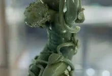 Close-up view of the pale green Lycurgus Cup showing a figure entangled in carved vines.