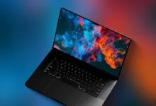 MacBook Pro with colorful abstract blue and red smoke wallpaper on a gradient background