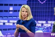 Marissa Mayer speaking on stage in a blue dress at a Fortune conference