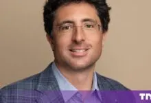 Headshot of business leader Niccolo de Masi wearing glasses and a plaid blazer.