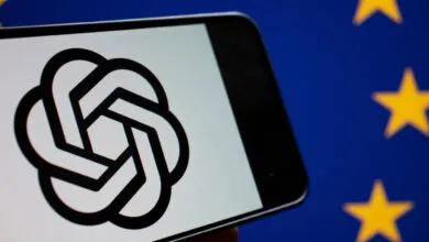 Smartphone displaying the OpenAI logo in front of the European Union flag