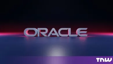 3D Oracle logo illuminated by pink and blue lighting on a dark background