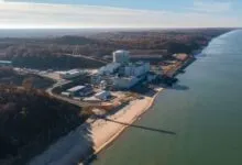Aerial view of Palisades Nuclear Power Plant situated on the Lake Michigan shoreline with autumn forests