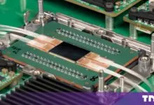 Close-up of an advanced photonic switch chip integrated with fiber optic cables on a green circuit board.