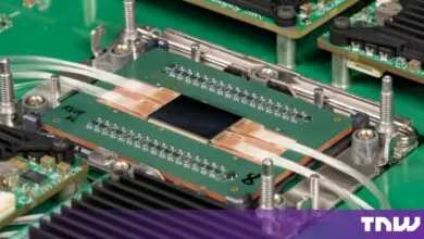 Close-up of an advanced photonic switch chip integrated with fiber optic cables on a green circuit board.