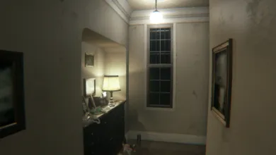 Creepy, dimly lit hallway with a vintage desk, lamp, framed pictures, and a tall window at the end.