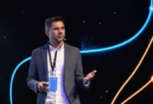 Rohit Patel delivering a keynote presentation on a brightly lit stage
