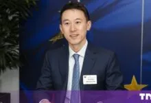 TikTok CEO Shou Zi Chew smiles during a meeting in front of an EU flag background