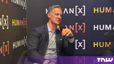 Steve Lucas, CEO of Boomi, speaking into a microphone seated in front of HumanX event branding