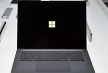 Close-up of a Microsoft Surface Laptop displaying the Windows logo on a black screen.