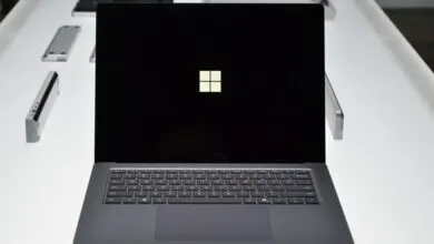 Close-up of a Microsoft Surface Laptop displaying the Windows logo on a black screen.