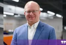 Tim Heidel wearing a blue blazer on a factory floor