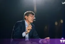 Vittorio Colao speaking and gesturing on stage at the Wave by Vento event in Turin