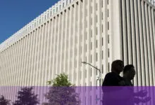 Low angle shot of the massive World Bank building facade in Washington D.C. with pedestrians walking past.