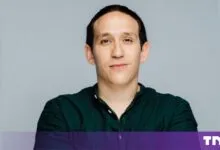 Portrait of Zacharie Lahmi, founder of Ellis & Partners, wearing a dark green shirt.